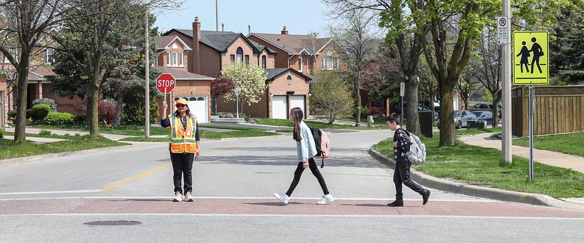 Children crossing the road with the help of a crossing guard