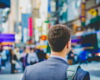 man in business attire walking in a city