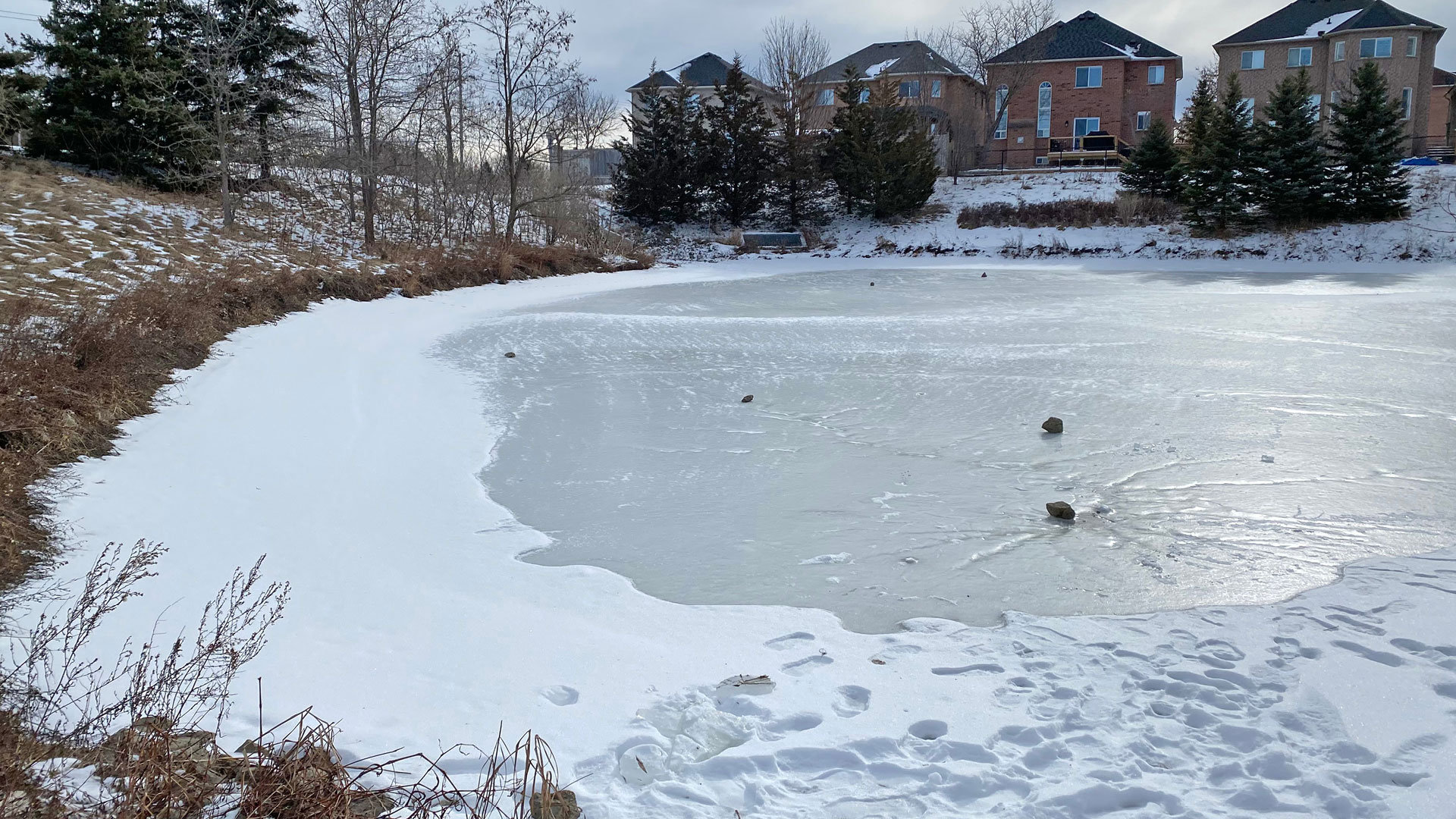 Frozen stormwater pond with snow on top