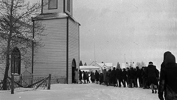 Image of students walking in the snow to a service at St. Thomas Anglican Church, Moose Factory Island, January 1946