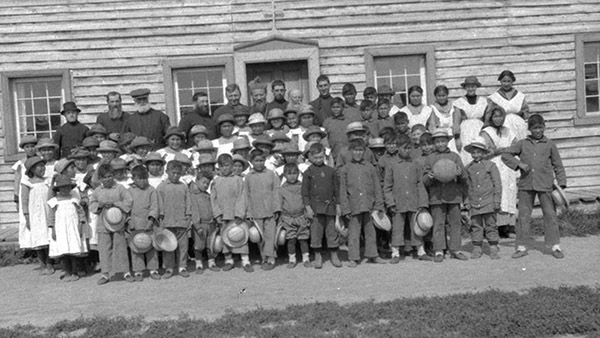 Image of students standing in front of Fort Providence Indian Residential School, Northwest Territories, Canada, 1920