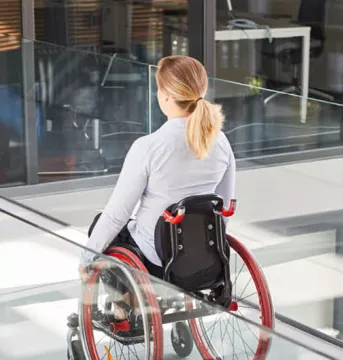 Women in wheelchair heading into an office