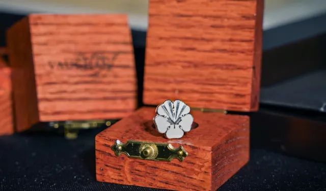 White flower pin with the City of Vaughan's logo engraved. Pin is in a wooden box.