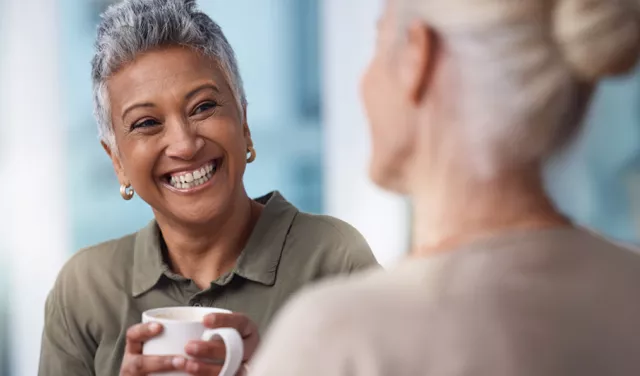 2 women having a discussion and holding coffee