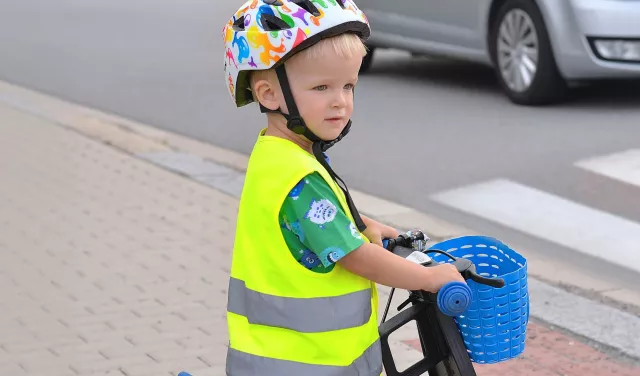 Little boy trying to cross the road with his bike
