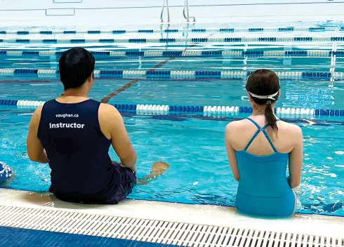 Child and instructor by the pool