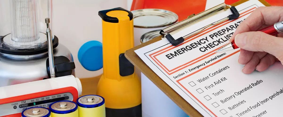 A person going through a checklist regarding "Emergency Preparation".