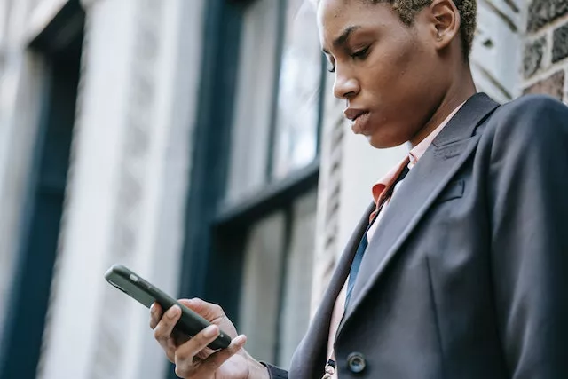 A person holding and looking at a cellphone.