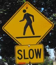 A pedestrian ahead sign displaying the words "Slow".
