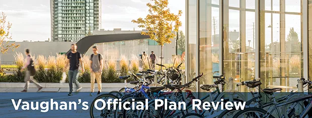 Bicycle's lined up on a bike rack with people walking in the background.