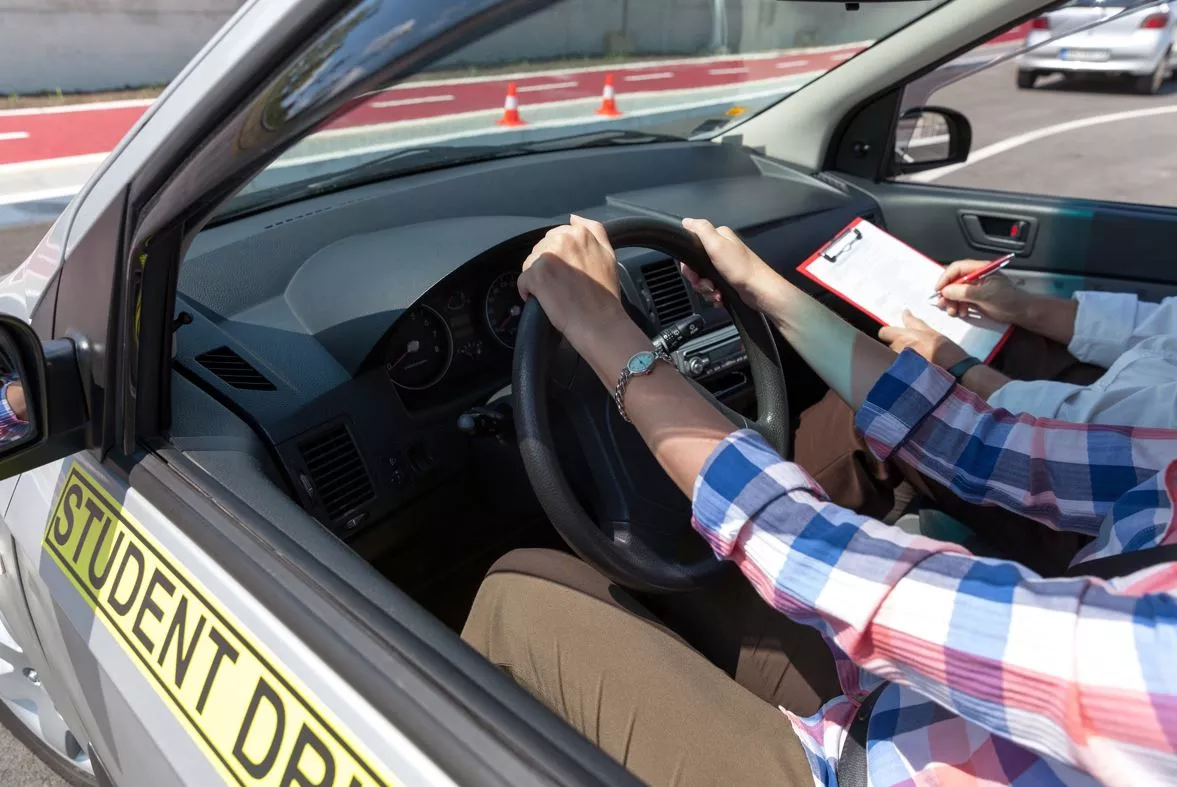 Person in car receiving driving lessons with instructor