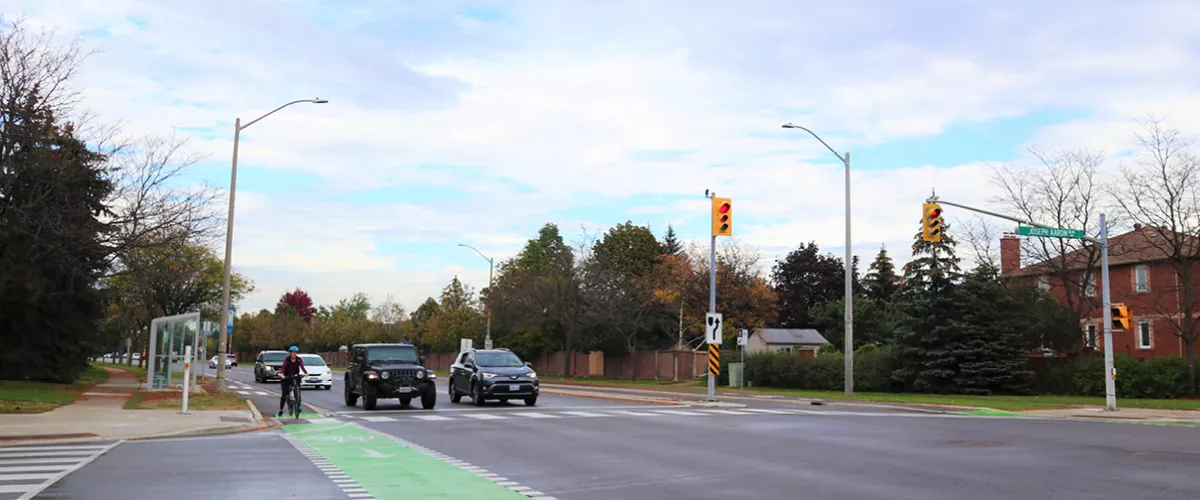 Image is of New Westminster Drive and how it currently looks. Image features cycle tracks and street traffic.