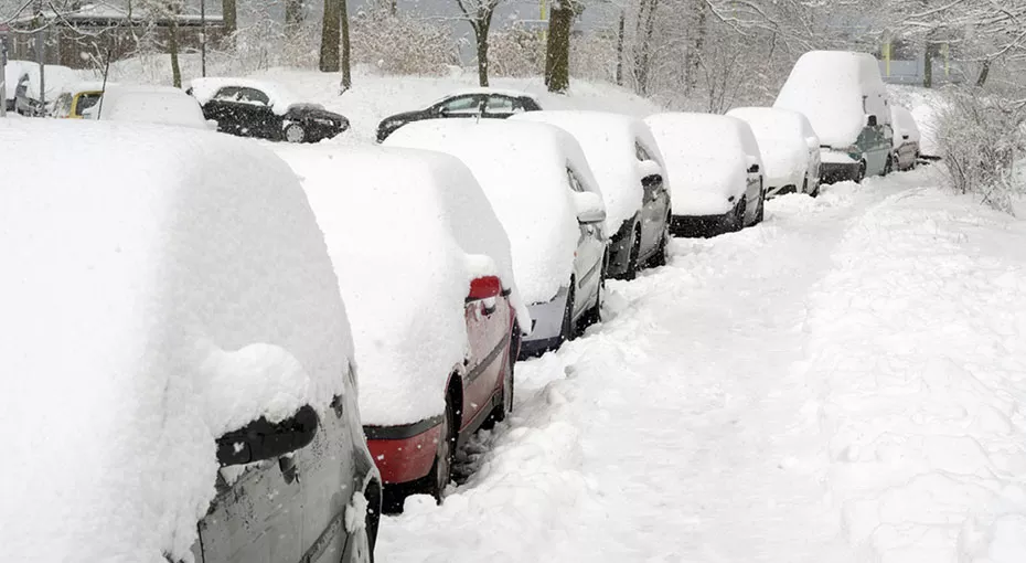 Cars parked on the street covered in snow