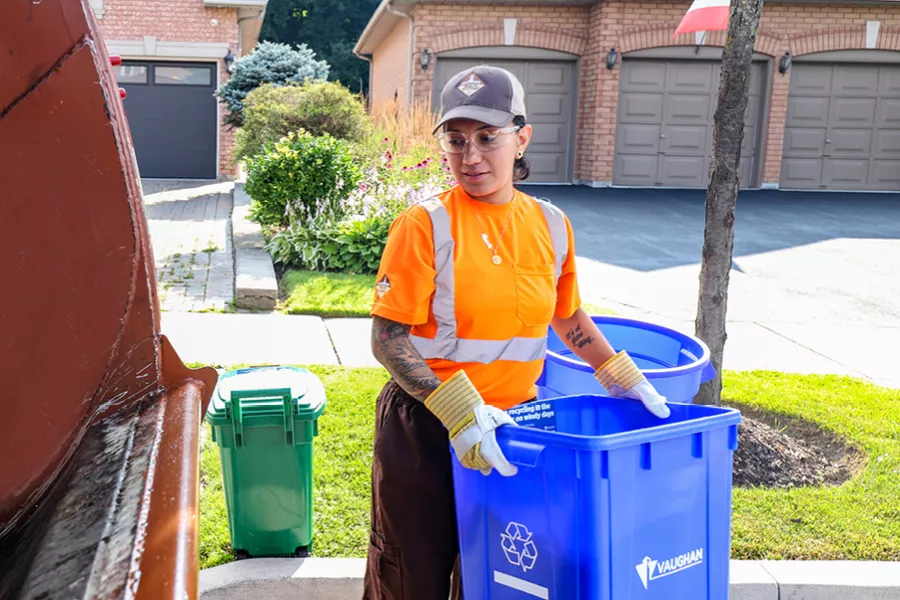 a waste collector holding a blue box