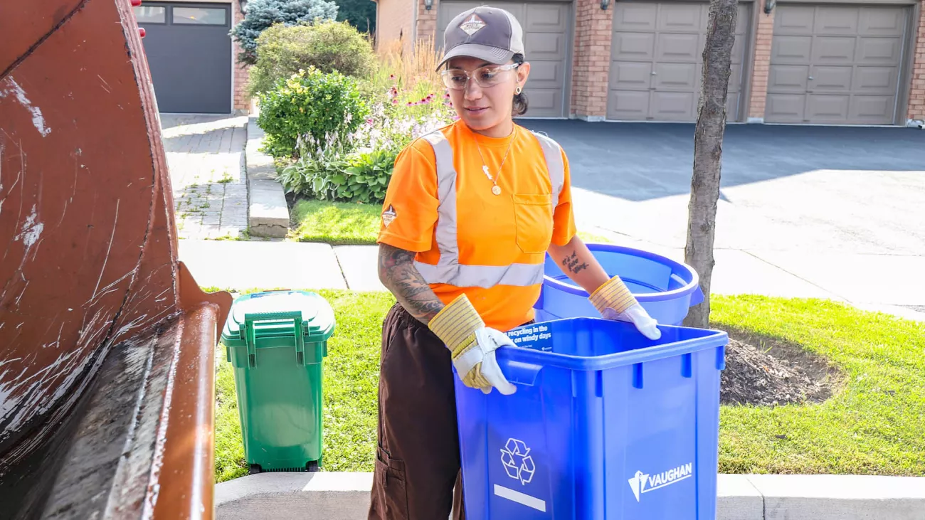 a waste collector holding a blue box