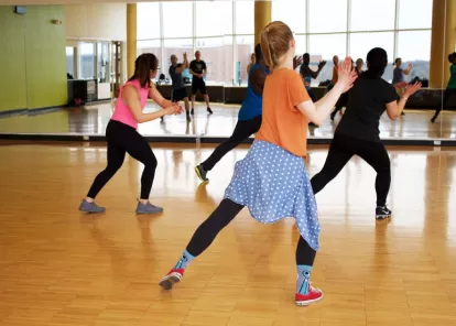 small group of adults in a dance or aerobics class in front of a mirror