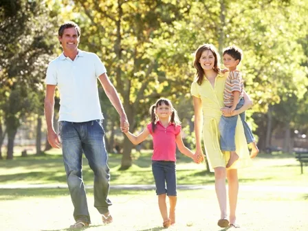 A family of four walking outside.