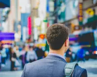 man in business attire walking in a city