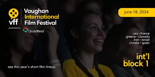Women watching a movie in a theater laughing.