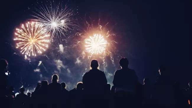 People looking up and watching fireworks in the night sky