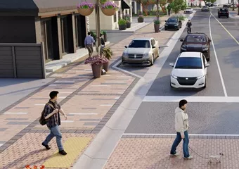 Concept image of a crosswalk with two individuals crossing the street in front of stopped cars.