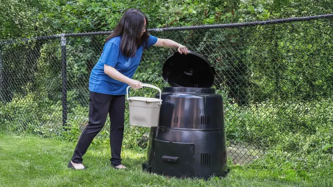 someone putting organics into a composter