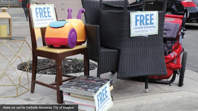 Chairs and toys at the curbside with "FREE" signs on them.