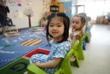 Preschool asian girl sitting and smiling at camera