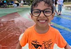 Child at splash pad smiling