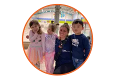 A camp counsellor posting with three young campers.