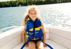 girl wearing a lifejacket sitting on a boat