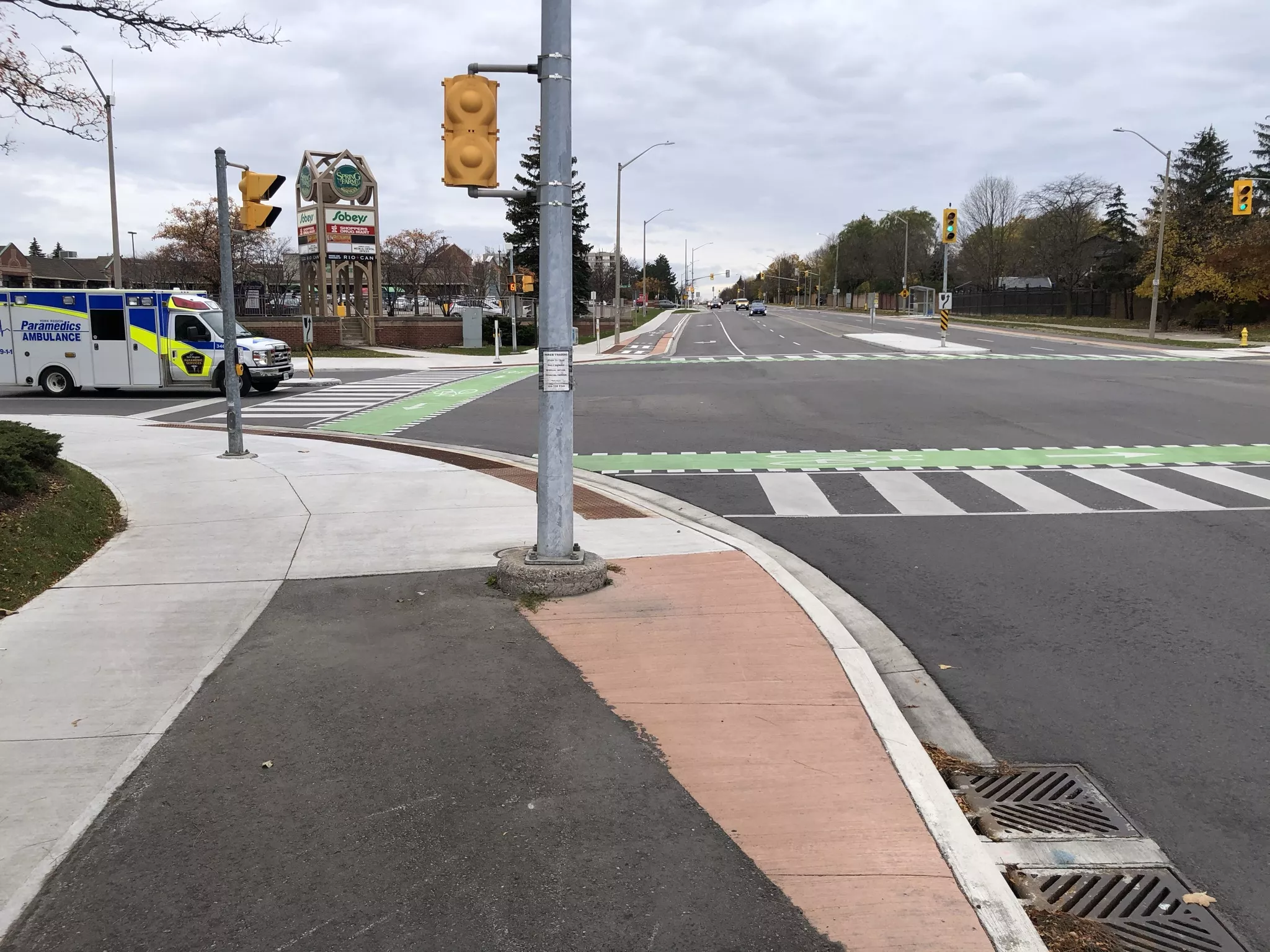 Intersection with shared space for cyclists and pedestrians. The cycle track directs cyclists onto the sidewalk where they would wait with pedestrians for the signal to change.
