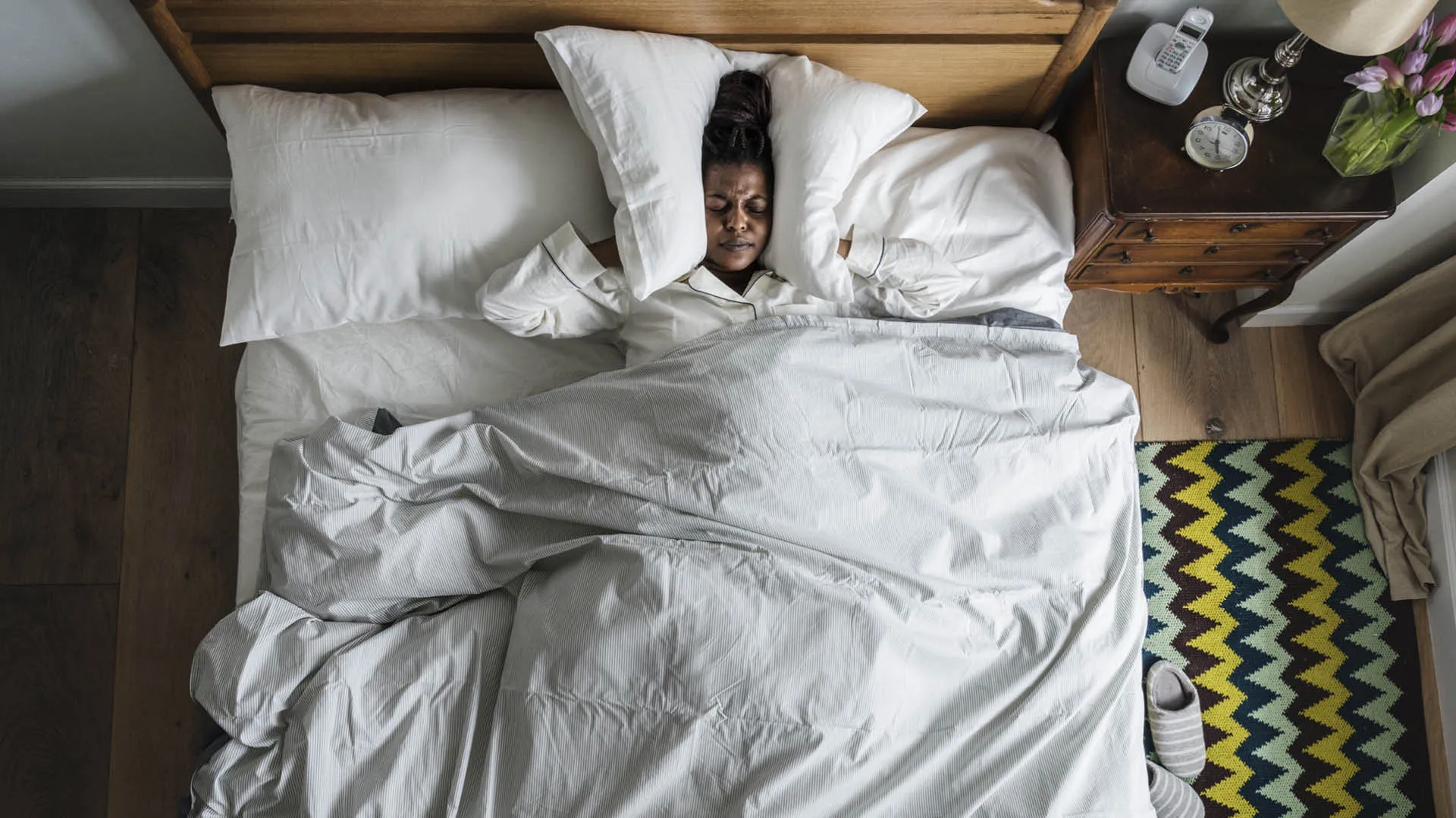 Person in bed listening to loud noises