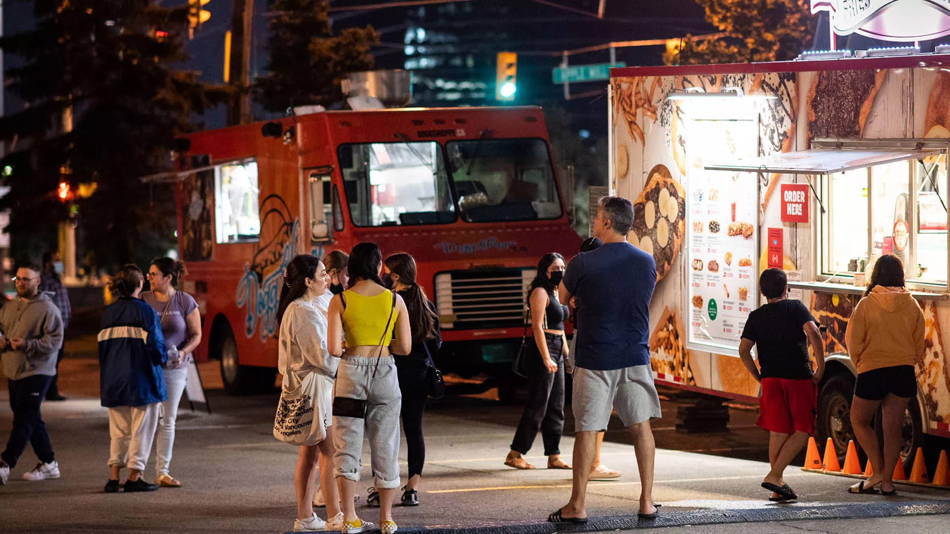 People lining outside a food truck at night