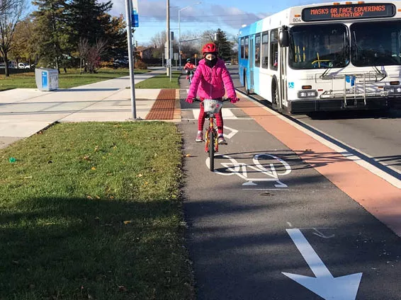Image shows a resident riding a bike in a cycle track. 