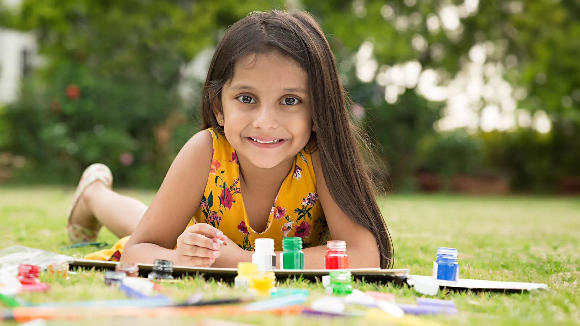 Girl painting outside in the grass