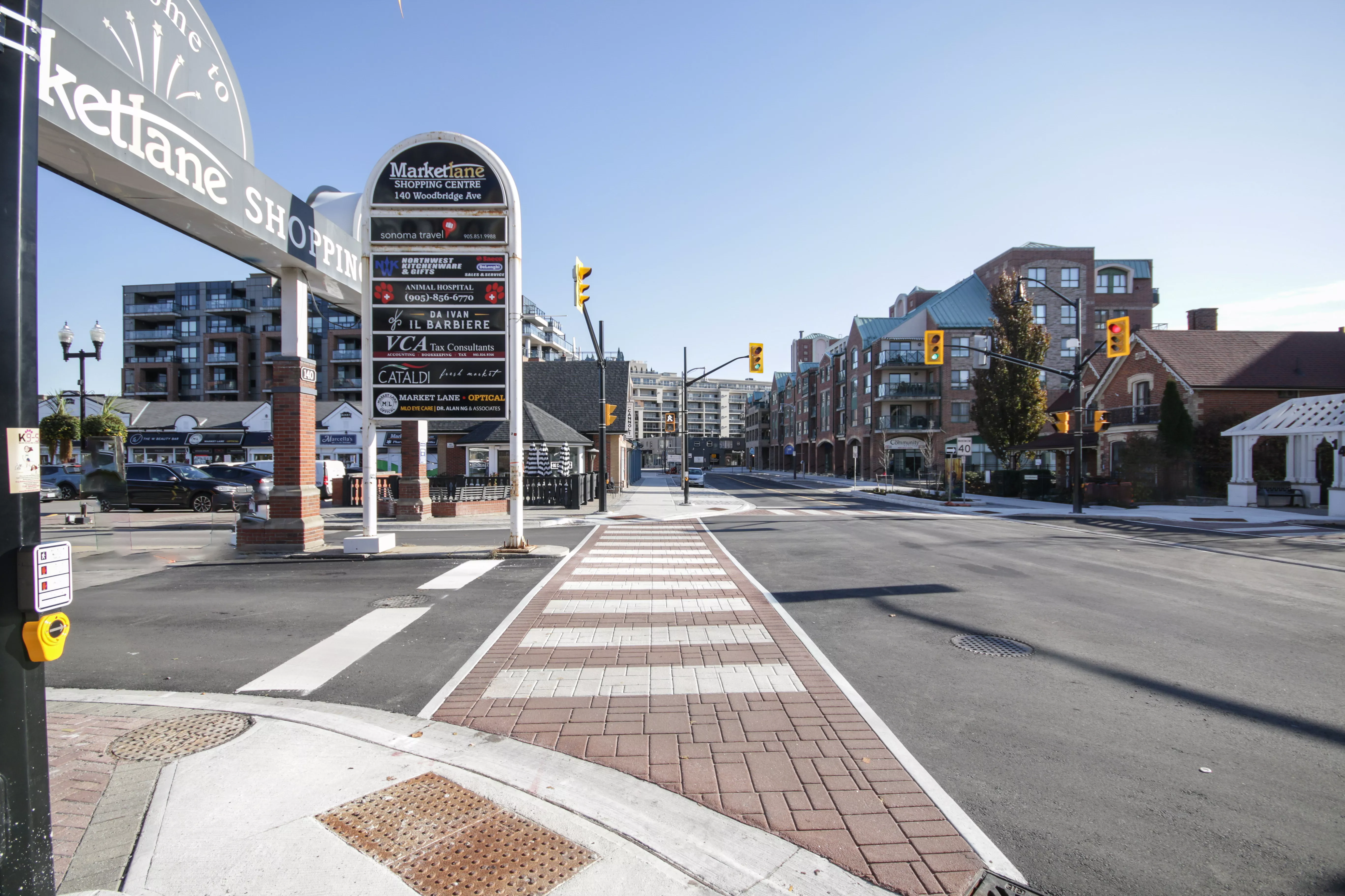 This image shows the entrance to the Marketlane Shopping Centre along Woodbridge Avenue and the enhanced roadway and sidewalk, as part of the Woodbridge Avenue improvements project..