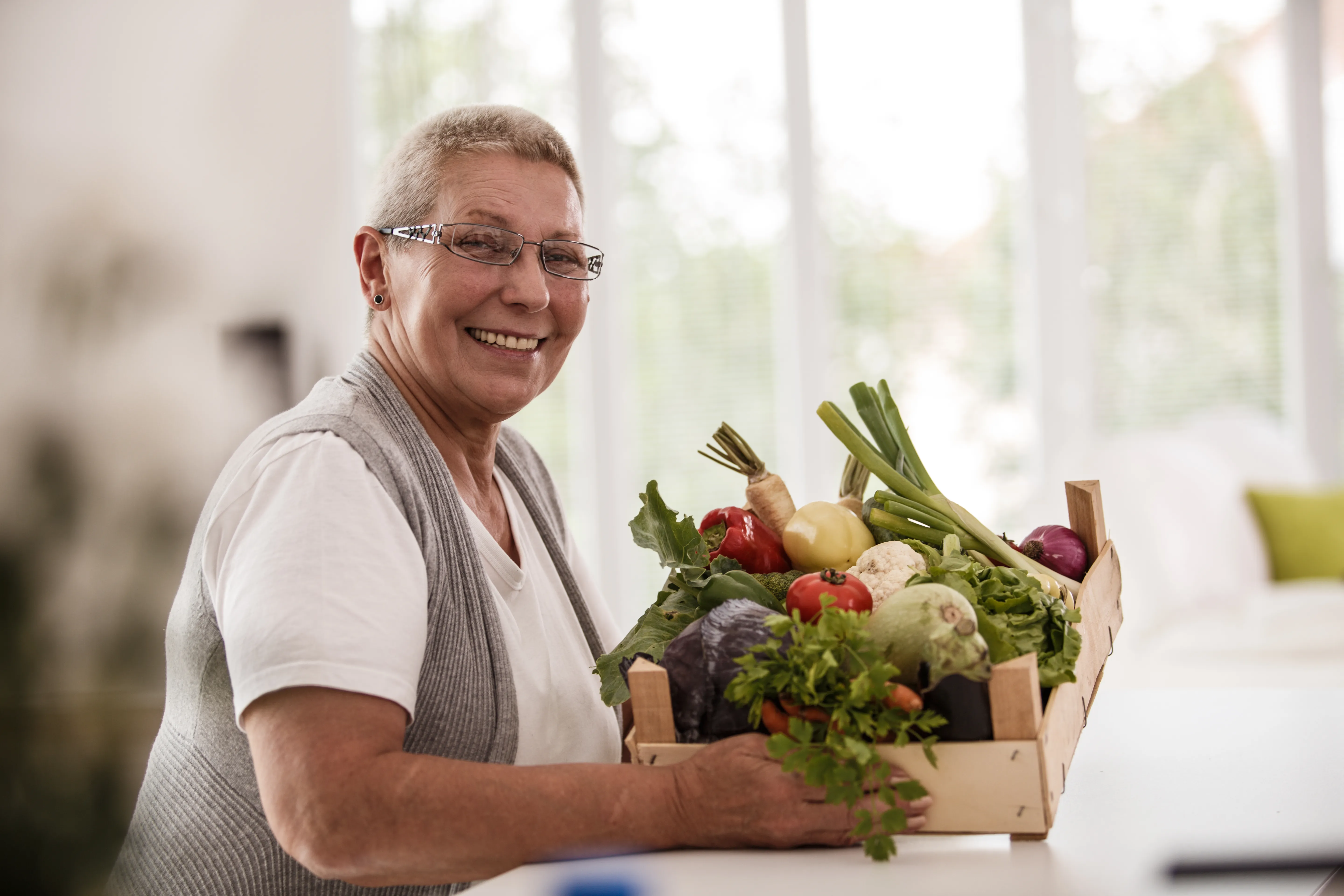 Lady holding box of veggies